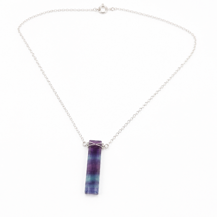 One purple and green striped fluorite bar pendant on a silver metal chain necklace.