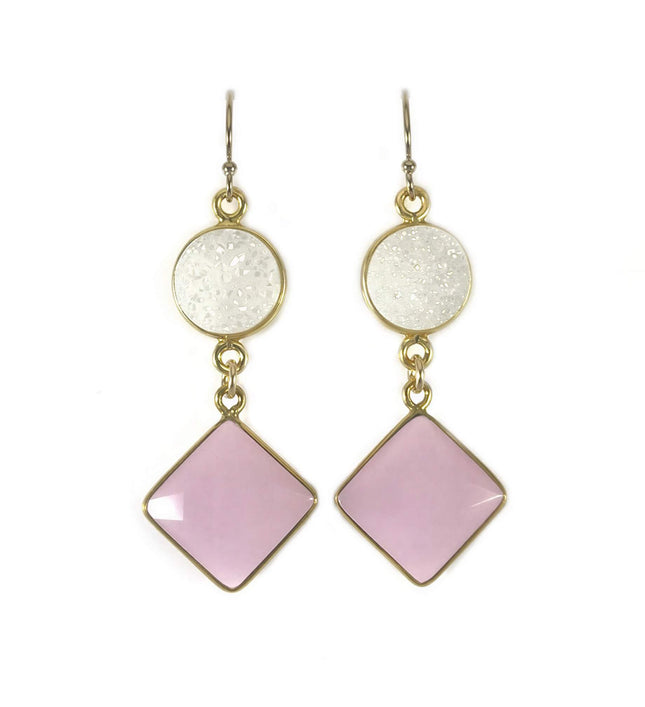 Pair of drop earrings with round white druzy and square pink stones in gold metal frames on a white background.