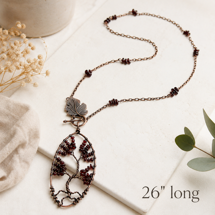 Copper wire tree of life pendant with red beads on a chain with leaf clasp and 26" long printed text.