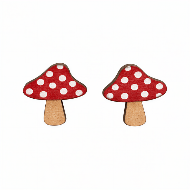 Two wooden mushroom stud earrings with red caps and white polka dots on a white background.